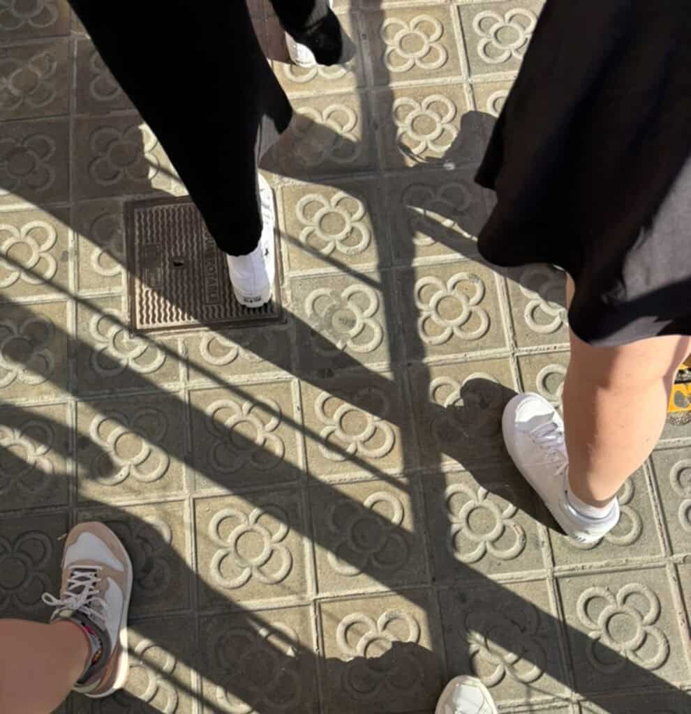 Group walking on a street paved with Barcelona's flower tiles