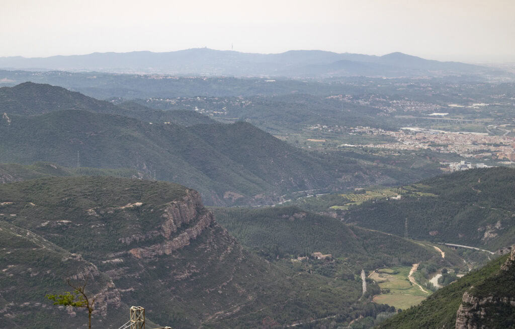 A landscape high up of the mountains and city below in Montserrat, Spain