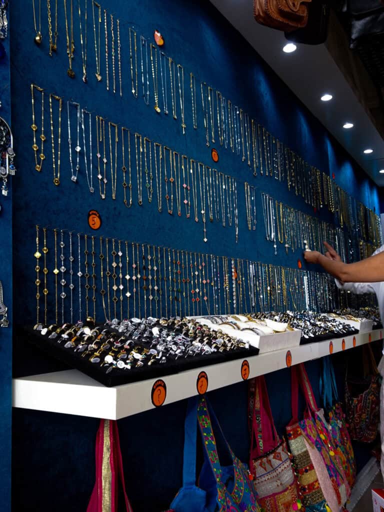 Customers browse a wall of jewelry items.