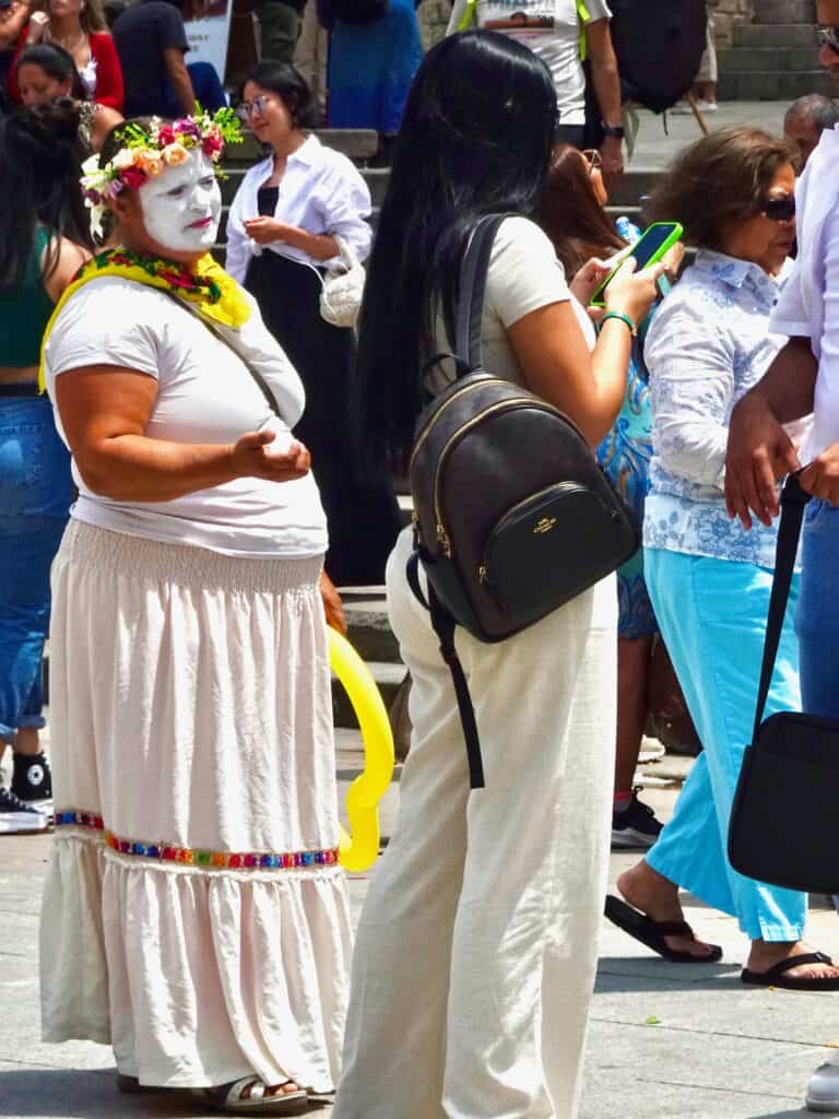 Cathedral Clown begs tourist for money.