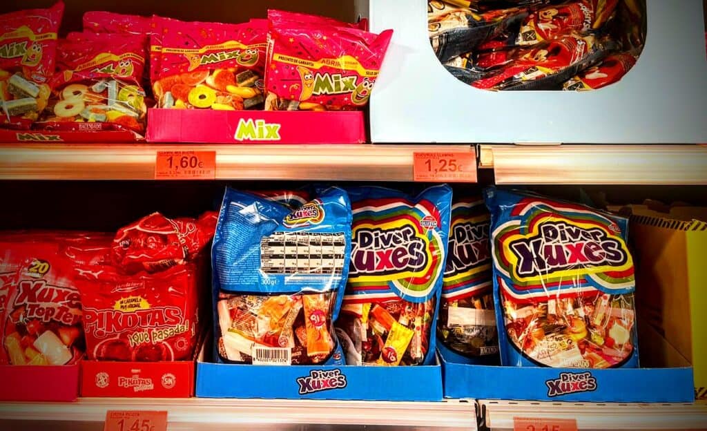 An image of bags of candy on the shelves of a grocery store.