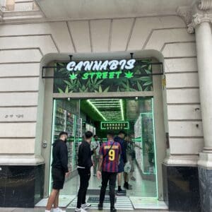 A photo of the front of a store named "Cannabis Street" with customers entering.