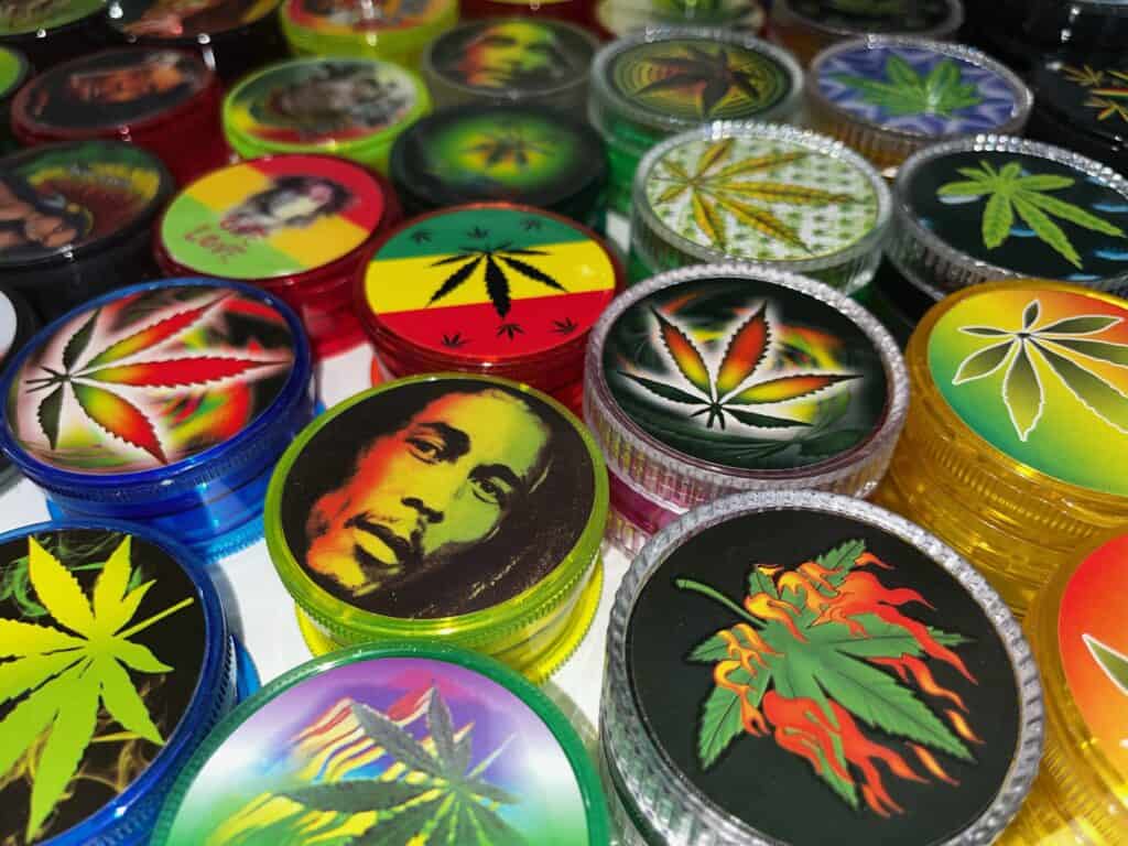 A photo with different variations of grinders with images such as Bob Marley and colorful marijuana symbols.