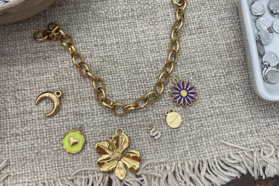 A gold charm bracelet with colorful and fun charms ready to be made.
