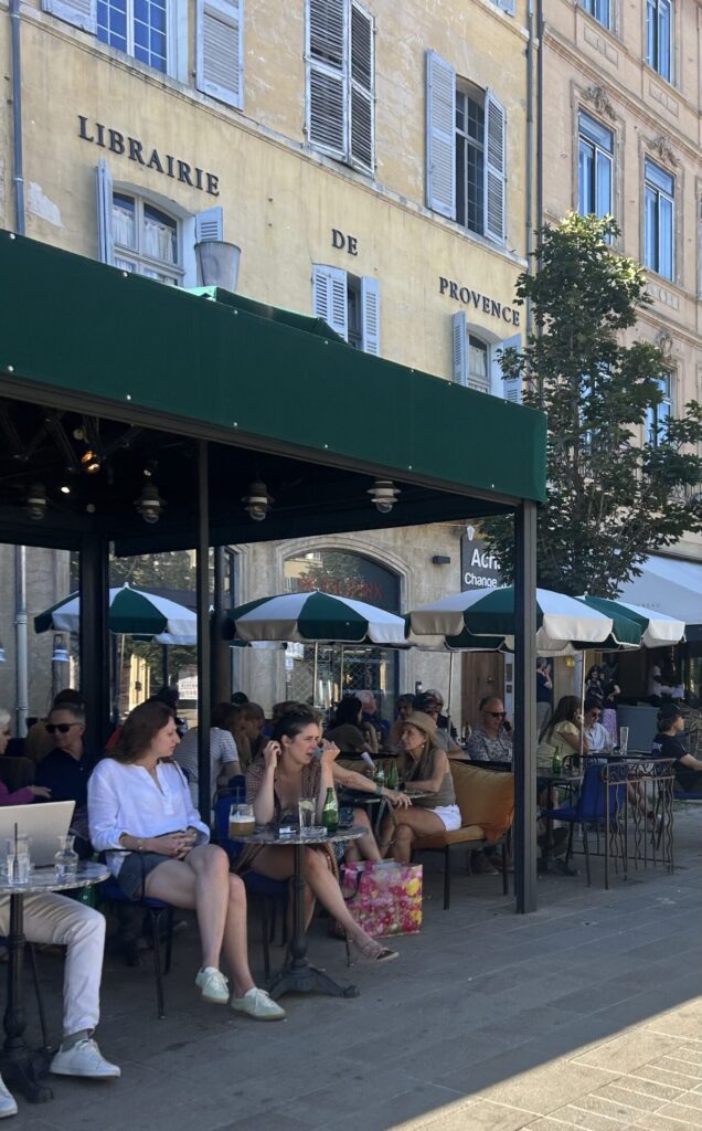 An outdoor french cafe with green and white umbrellas