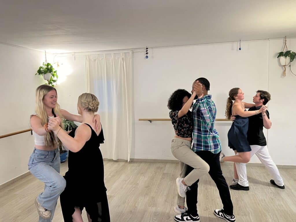 three pairs of people learning tango steps.