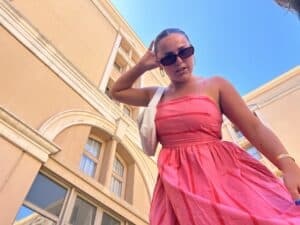 girl in pink dress wearing sunglasses and gold jewelry