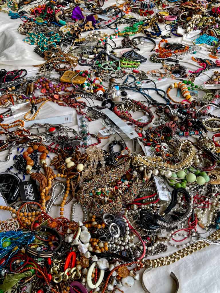 Numerous jewelry items lay scattered around a table.
