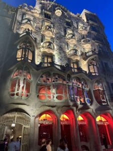 Casa Batlló lit up at night to show off unique architecture and bone like features on each balcony to show off his own funky style