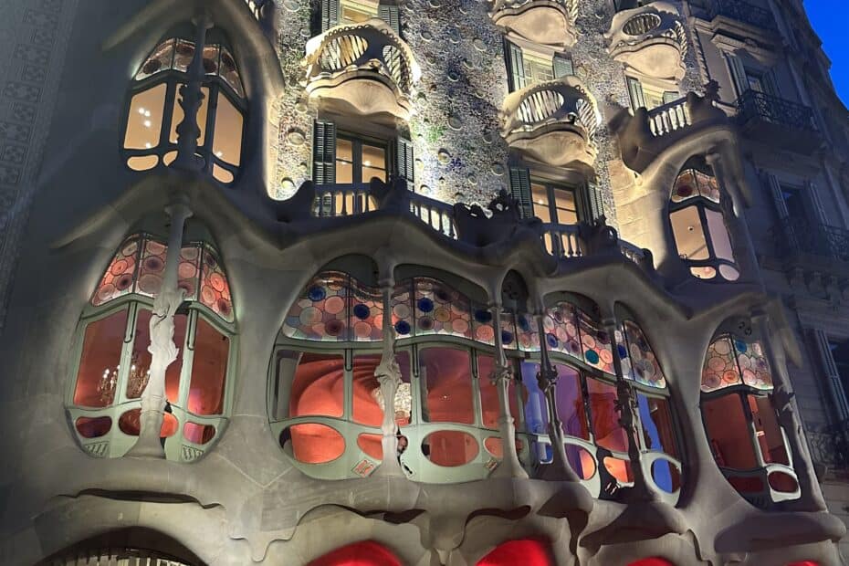 Casa Batlló lit up at night to show off unique architecture and bone like features on each balcony to show off his own funky style