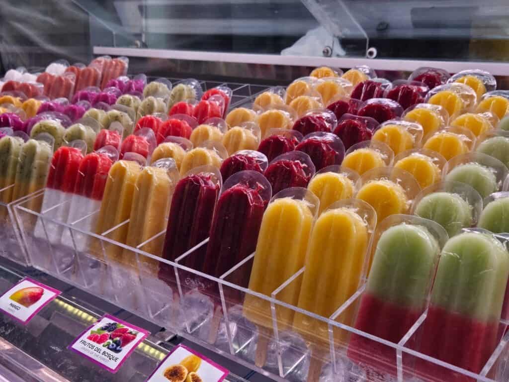 Fruit popsicles on market stand.