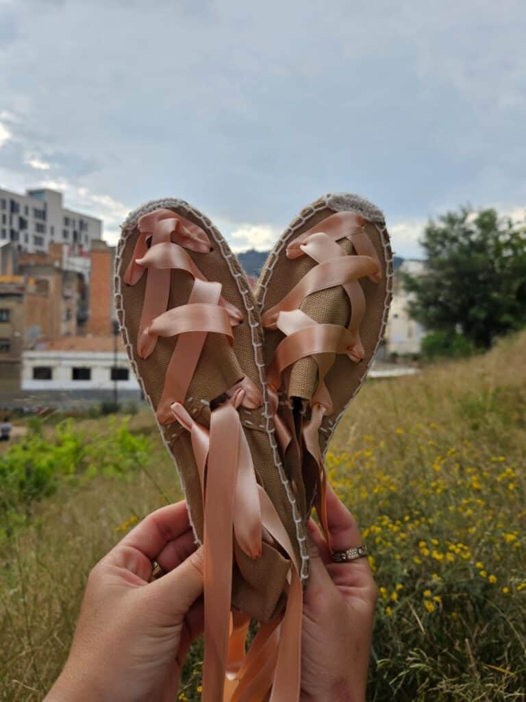 Espadrilles sewn with pink crosshatch ribbon to represent Catalan descent.