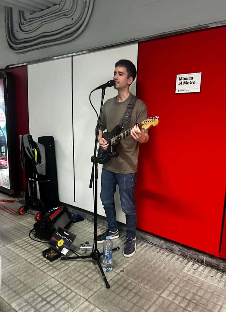 Man playing guitar and singing in the metro