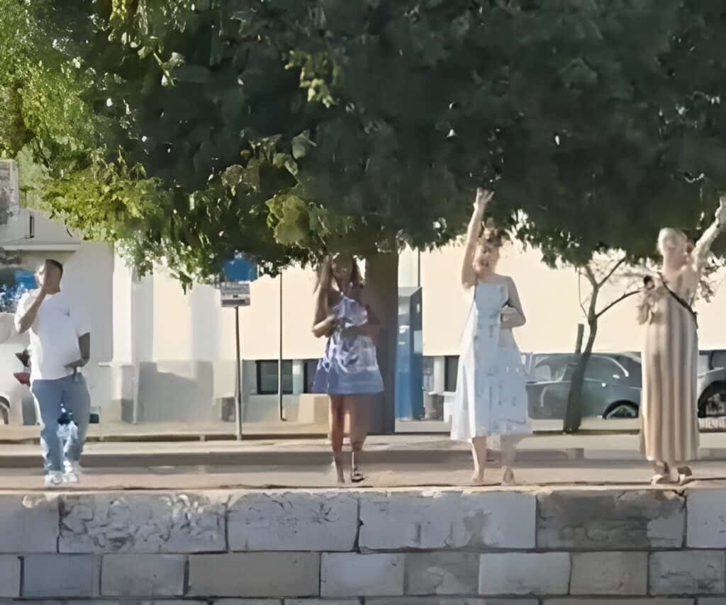 4 people waving goodbye to a boat