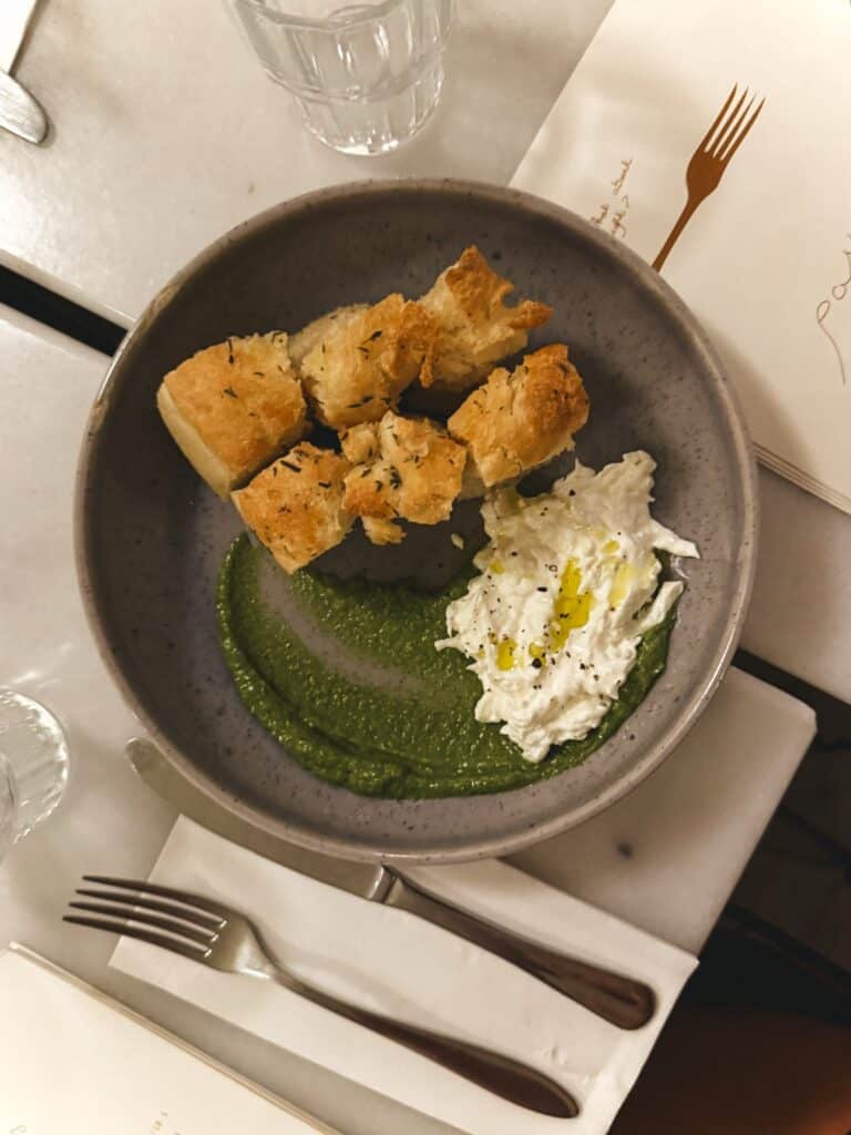 Image focaccia bread, stracciatella cheese, and pesto nicely plated.