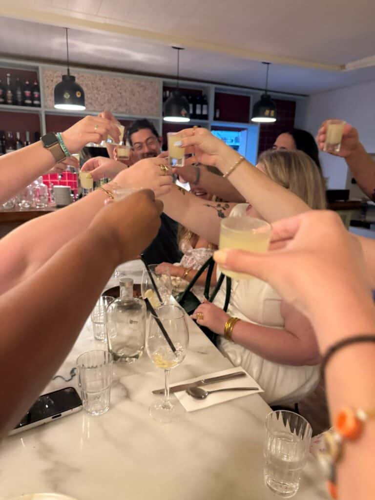 Image of a group of friends toasting limoncello shots after their meal.