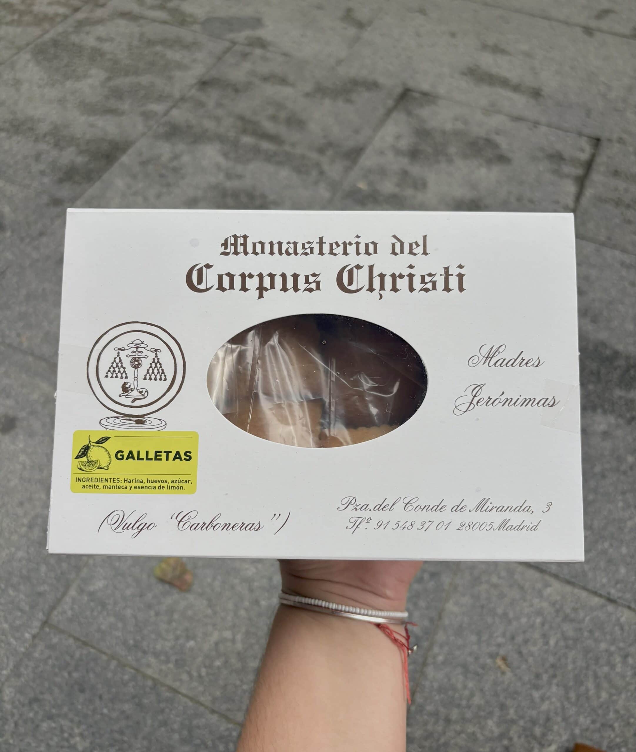 A white box full of cookies from the Reposteria. The words "Monasterio del Corpus Christi" adorn the box, and a yellow sticker labels the cookies as Galletas.