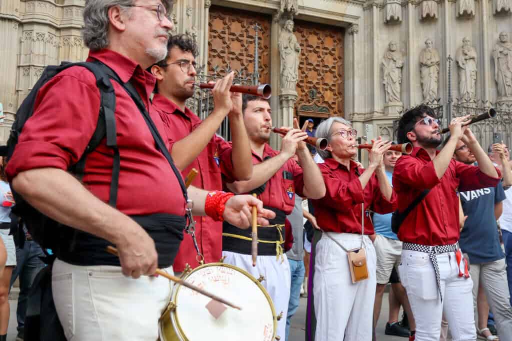 Musicians playing traditional Catalan instruments to the building of the castells