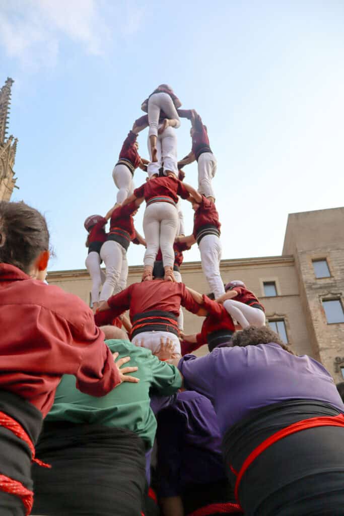 Base of a castell being supported by multiple color groups
