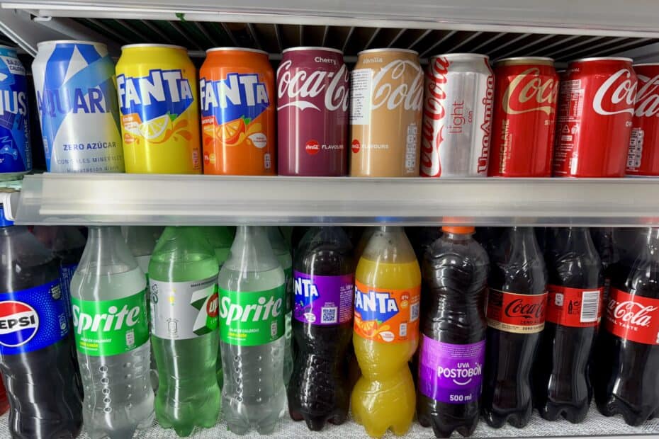 Sodas lined up in a supermarket fridge.