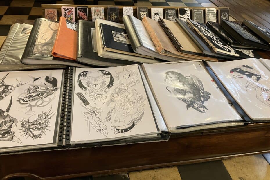 A layout of designs and books in the lobby of Meatshop Tattoo.