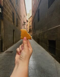 A hand holding a cookie in a street of Madrid