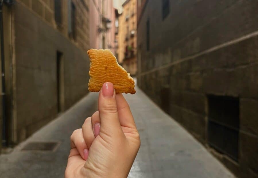 A hand holding a cookie in a street of Madrid