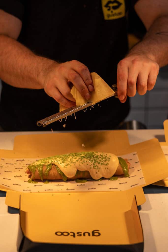 The chef grates Parmesan over a fresh